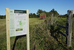 Sign and farming equipment at Castle Neck River Reservation