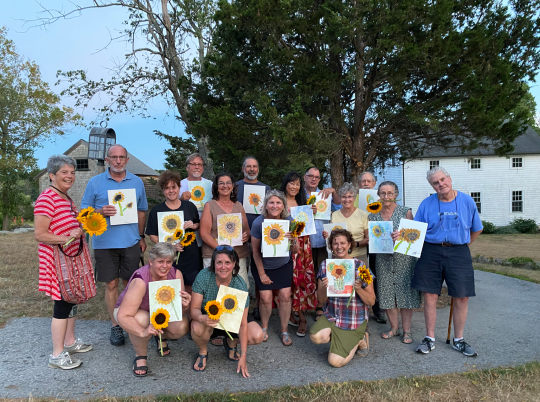 group holding sunflower watercolor paintings at Cox